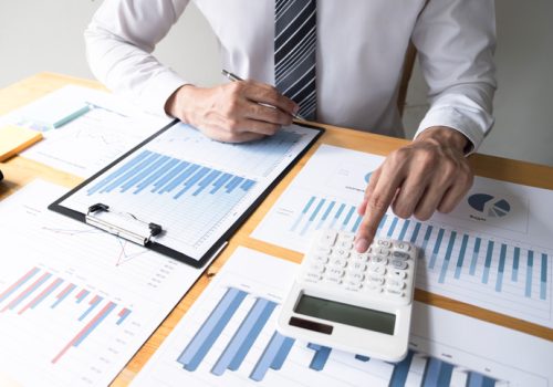 Businessman using calculator on the table in the office room. accounting calculation, concept.